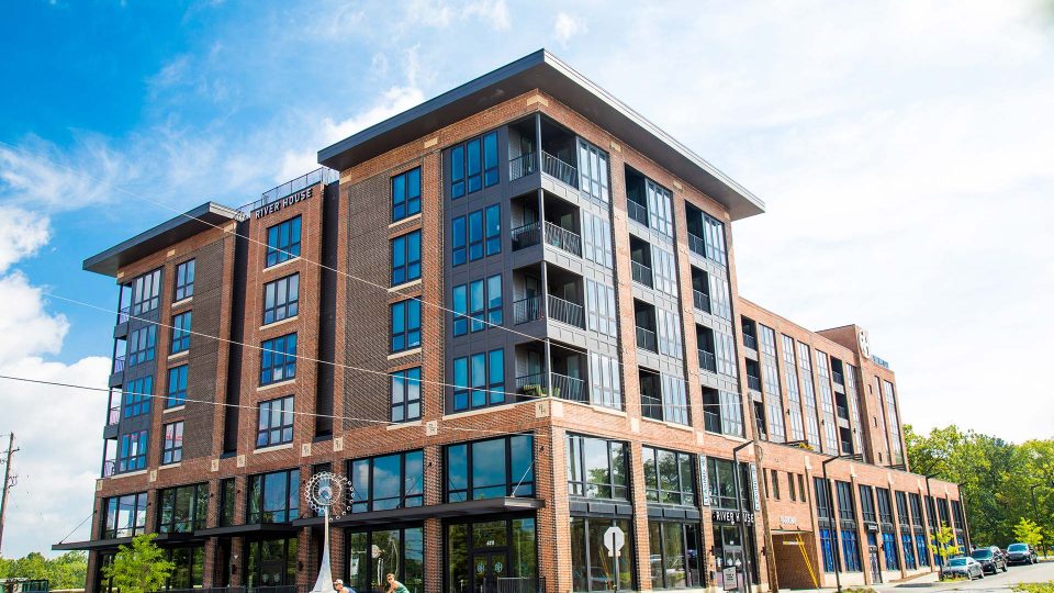 a large apartment building with windows on the side at The River House