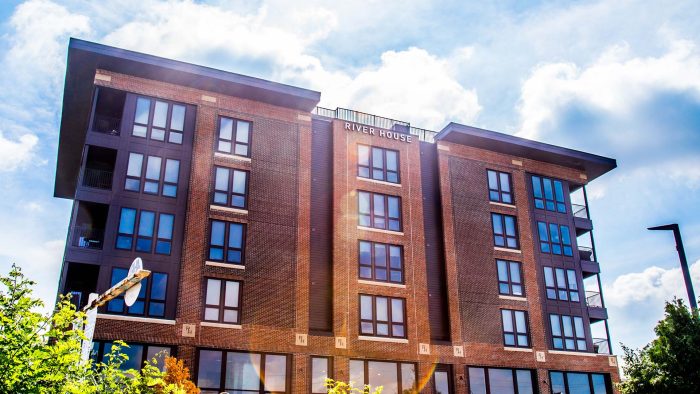 a large brick building with windows and a blue sky at The River House