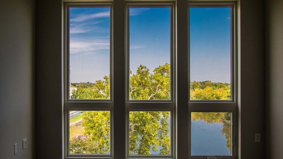 a room with three windows and a lake view at The River House