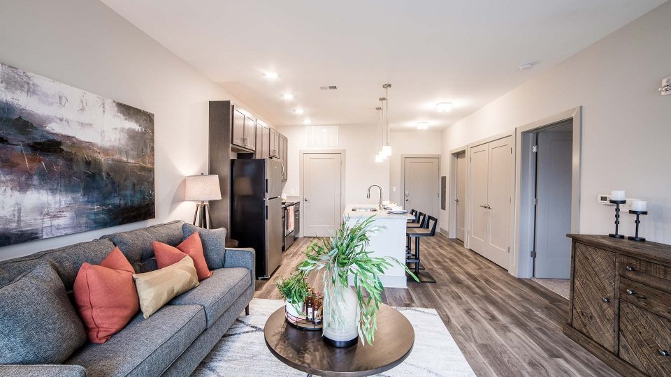 the living room and kitchen area of a new apartment at The River House