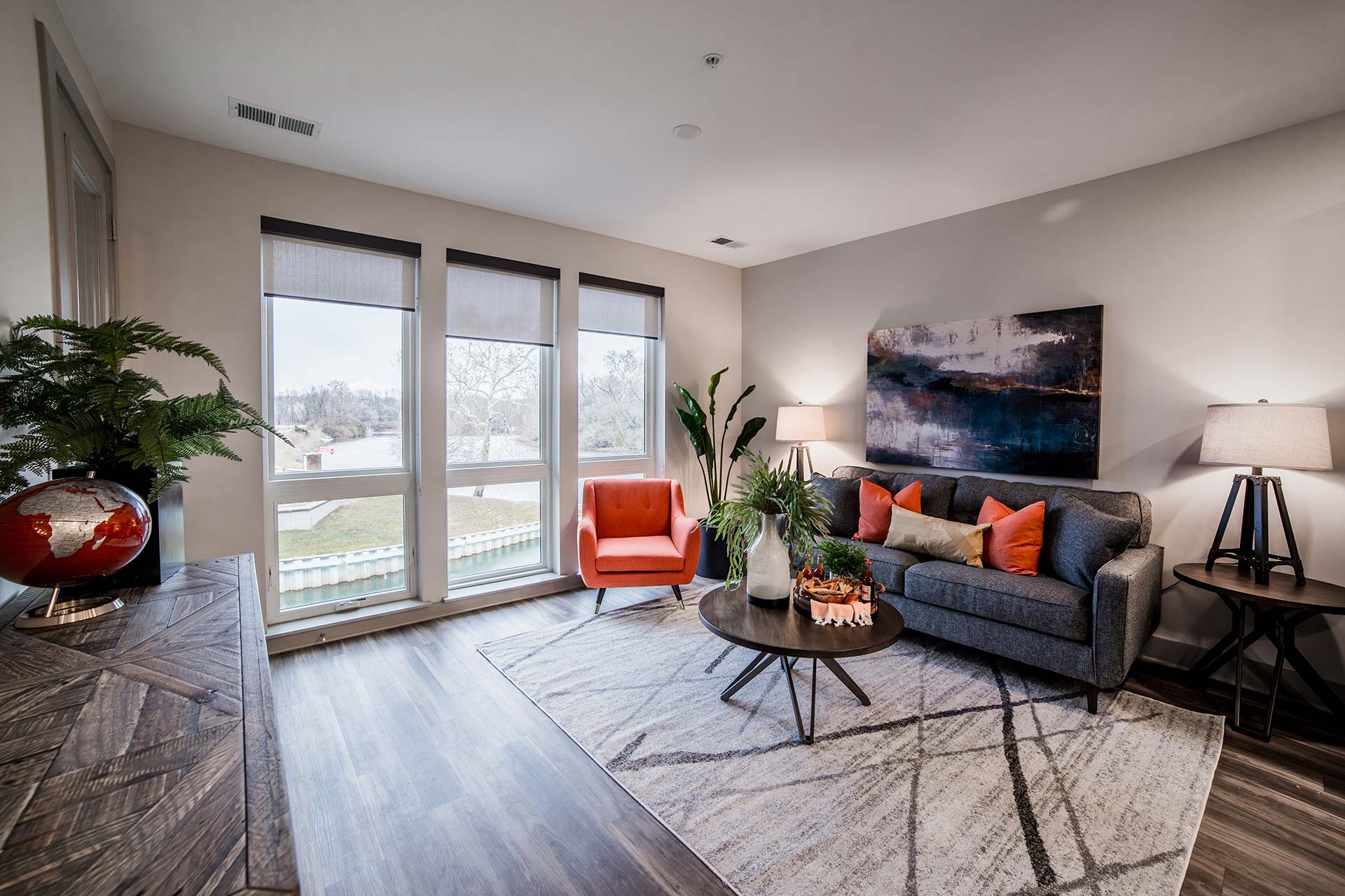 the living room has hardwood floors and a large window at The River House